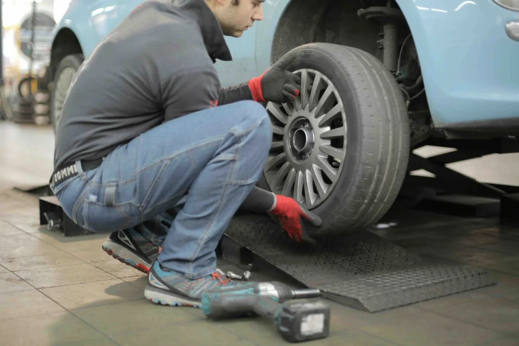 man fixing a tire on his car - dynamic number insertion for automotive industry