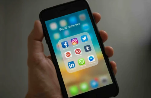 Person holding a phone showing its apps
